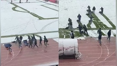 Aficionados del Zrich salen al campo a quitar la nieve... para que el partido pudiera continuar!