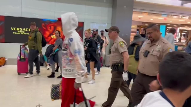 Odell Beckham Jr. is escorted by the police throught airport