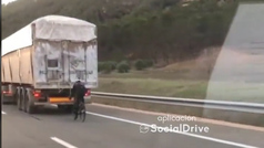 Este ciclista se la juega en autovía poniéndose a rebufo de un camión