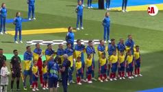  Los jugadores de Ucrania escuchan el himno envueltos en la bandera de su pas