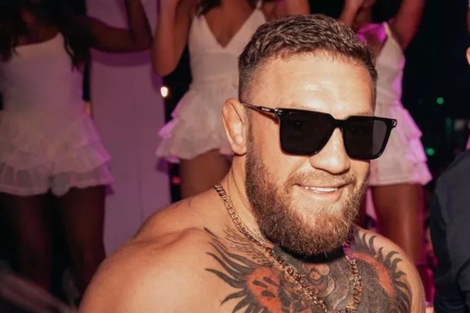 El luchador de artes marciales mixtas, el irlandés Conor McGregor (i), es escoltado mientars abandona una comisaria neoyorquina Justin Lane